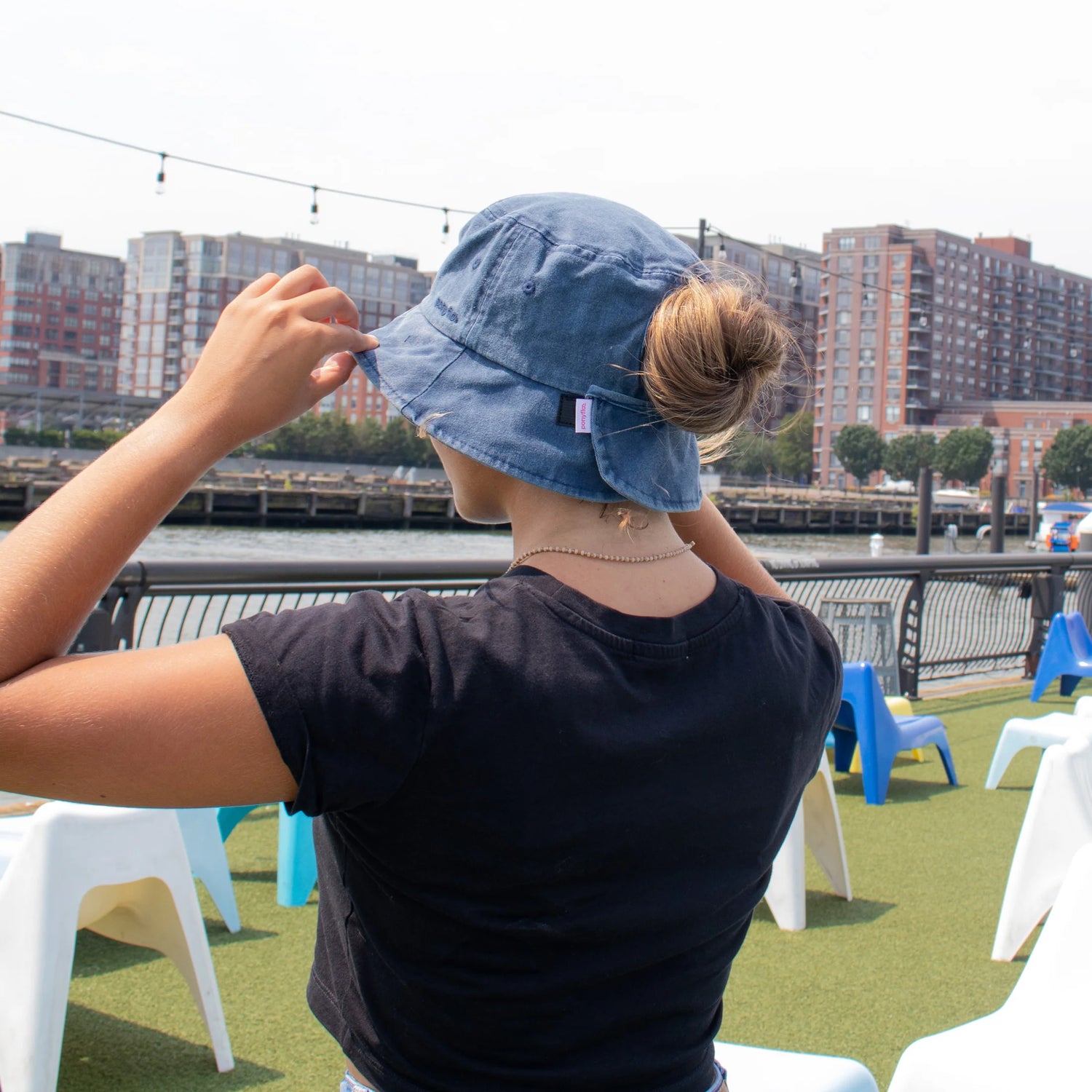 Mujer usando bucket hat azul con chongo