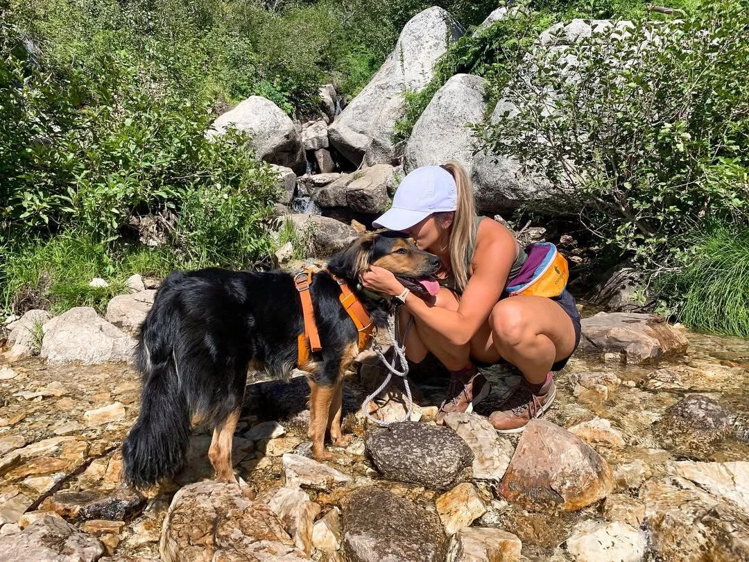 Mujer usando gorra para hike con su perro